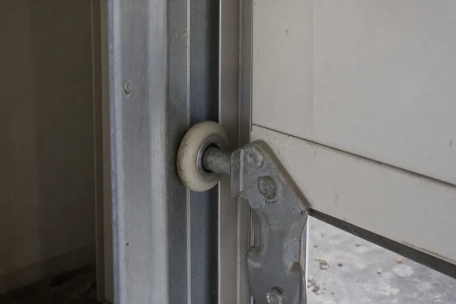 Hinges and roller along a panel seam of a garage door in Lincoln, NE